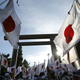 Members of nationalist movement "Ganbare Nippon" holding Japanese national flags gather under the huge Torii gate at the Yasukuni shrine while paying tribute to the war dead in Tokyo August 15, 2014,